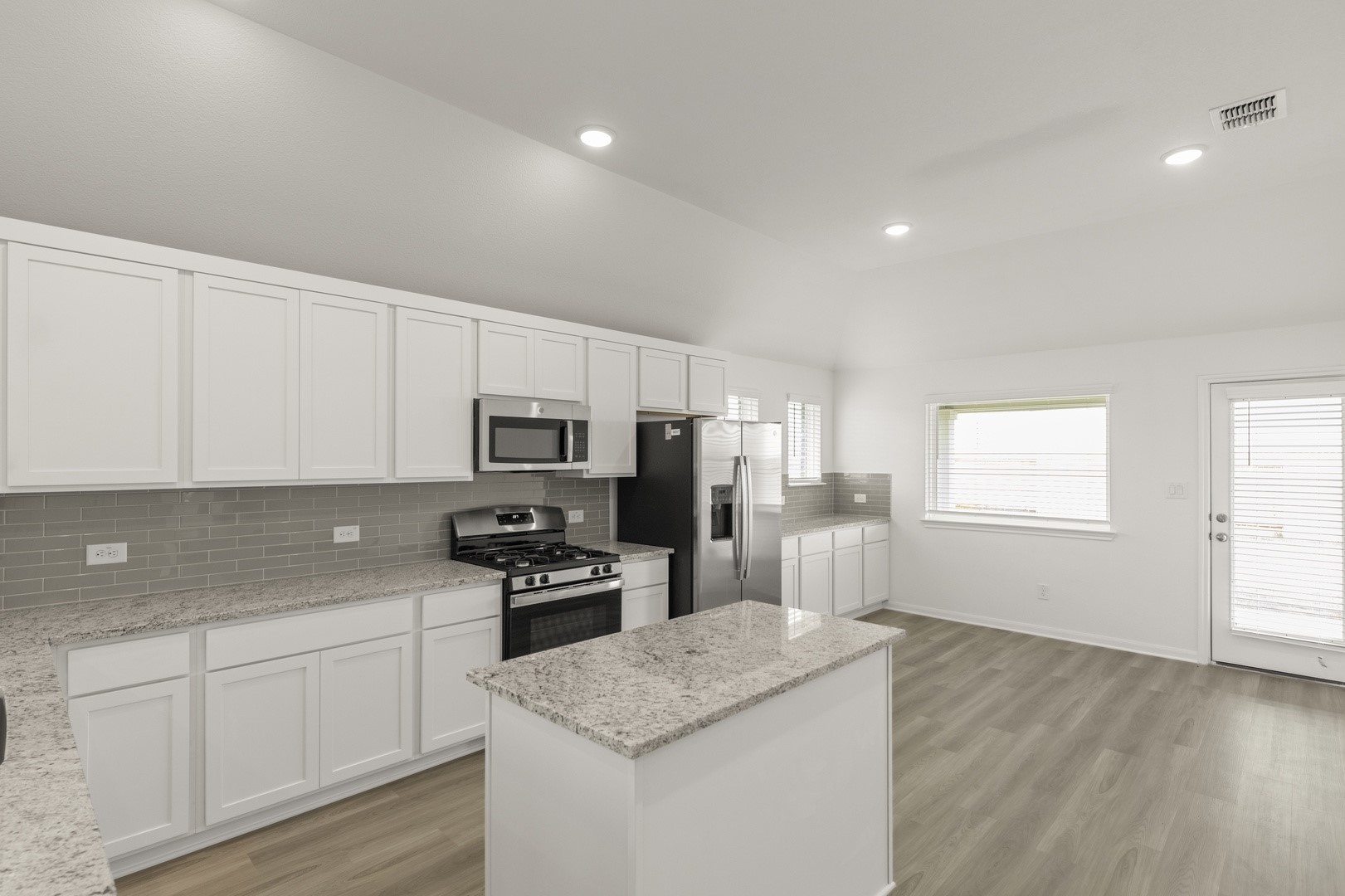 3729 Pin Oak Hills Seguin, TX 78155 - Photo 6 of 22 Kitchen with white cabinets, appliances with stainless steel finishes, tasteful backsplash, a center island, and light wood-style floors