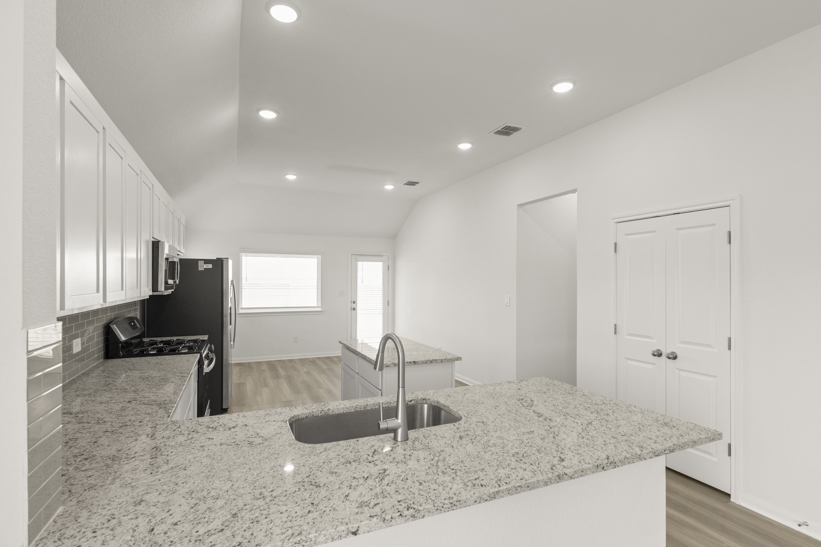 3729 Pin Oak Hills Seguin, TX 78155 - Photo 7 of 22 Kitchen featuring a peninsula, white cabinetry, appliances with stainless steel finishes, light wood-style flooring, and lofted ceiling