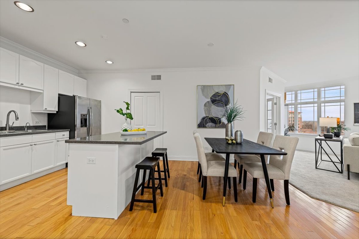 45 Prairie Park Drive, Unit 501 Wheeling, IL 60090 - Photo 8 of 30 a kitchen with stainless steel appliances a dining table chairs stove refrigerator and cabinets