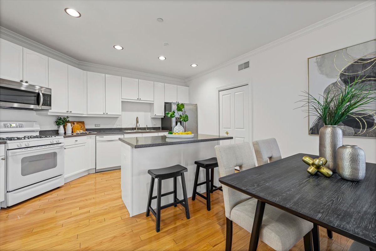 45 Prairie Park Drive, Unit 501 Wheeling, IL 60090 - Photo 9 of 30 a kitchen with a table chairs refrigerator and cabinets