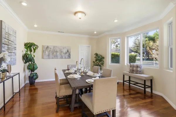 a dining room with furniture potted plants and wooden floor