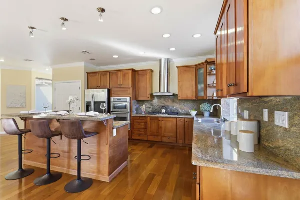 a kitchen with stainless steel appliances granite countertop wooden cabinets a stove top oven a sink and dishwasher