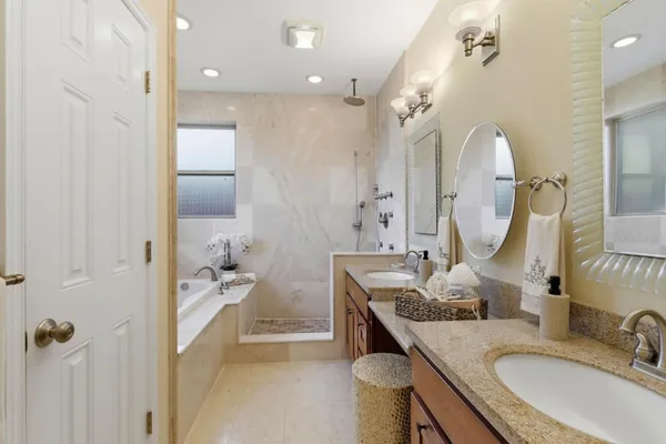 a bathroom with a granite countertop sink a mirror and shower