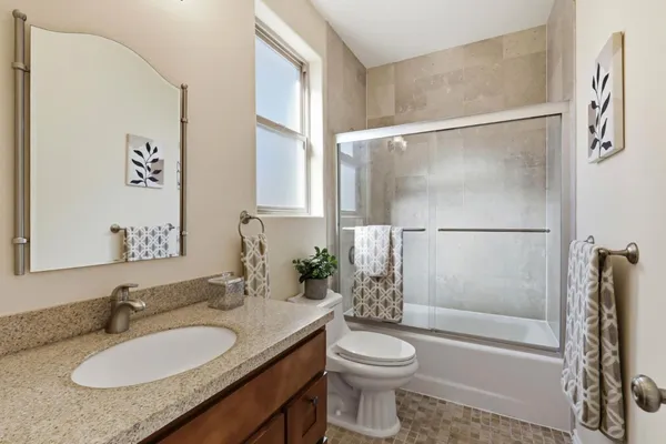 a bathroom with a granite countertop sink toilet and shower