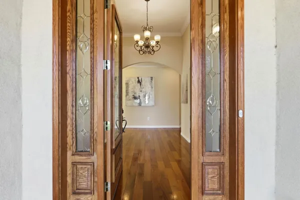 a view of a hallway with windows and chandelier