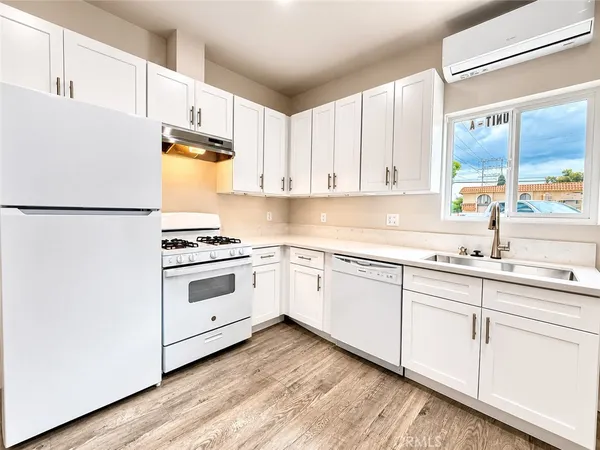a kitchen with granite countertop white cabinets and white appliances