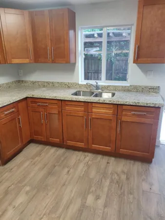 a kitchen with granite countertop a sink and cabinets