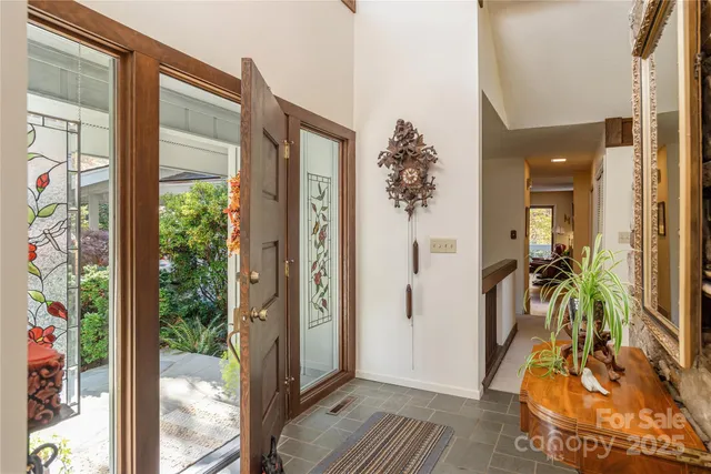 a view of a hallway with furniture and floor to ceiling window
