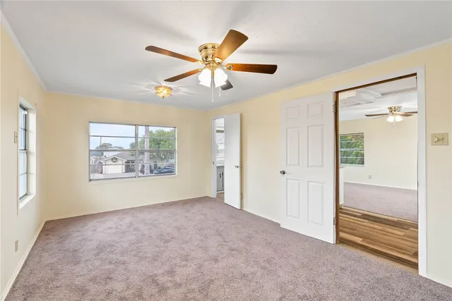 a view of room with a ceiling fan and a window