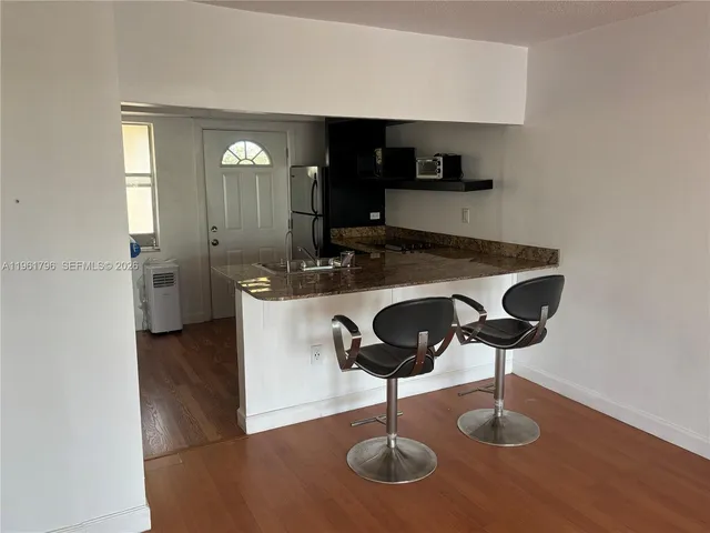 a kitchen with cabinets and chairs