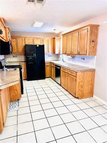 a kitchen with stainless steel appliances kitchen island granite countertop a refrigerator and sink
