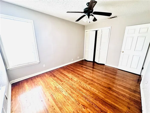 a view of empty room with wooden floor