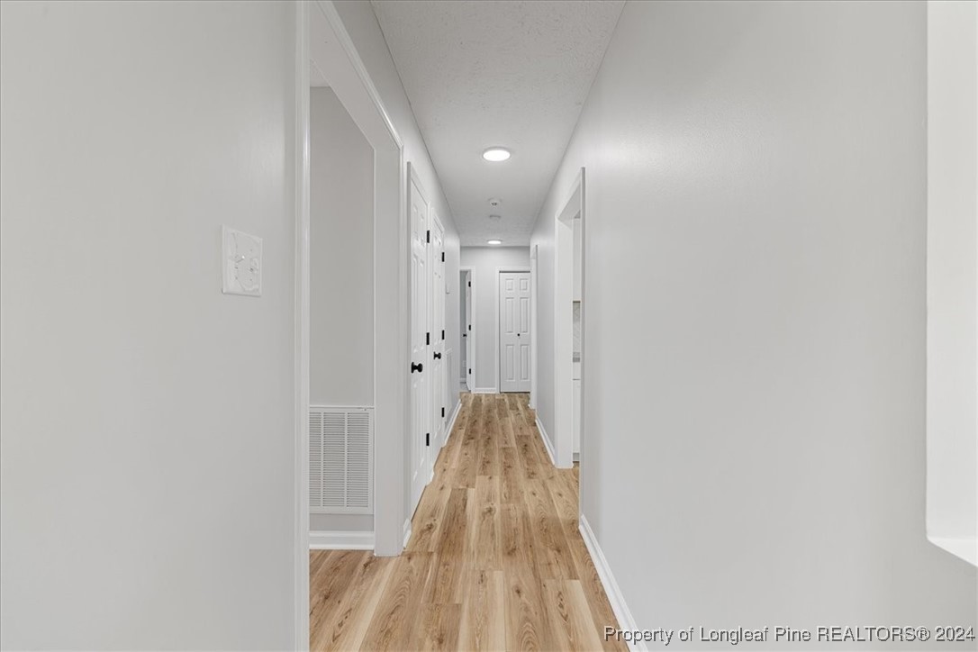 7847 Amesbury Road Fayetteville, NC 28311 - Photo 16 of 42 a view of a hallway with wooden floor
