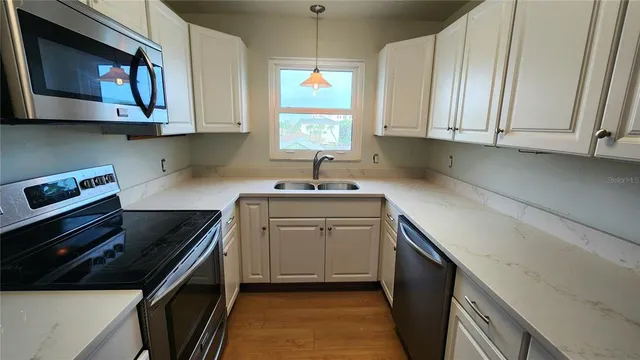a kitchen with stainless steel appliances a stove a sink and a microwave