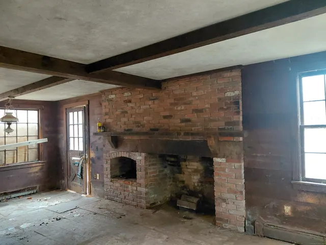 an empty room with fireplace and windows