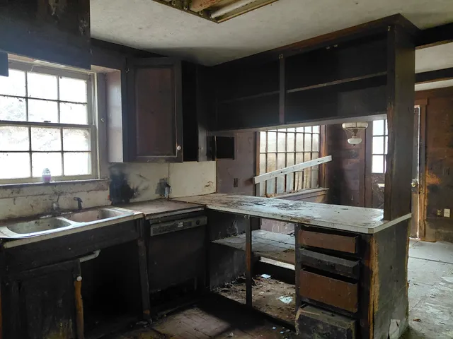 a kitchen with a sink window and cabinets