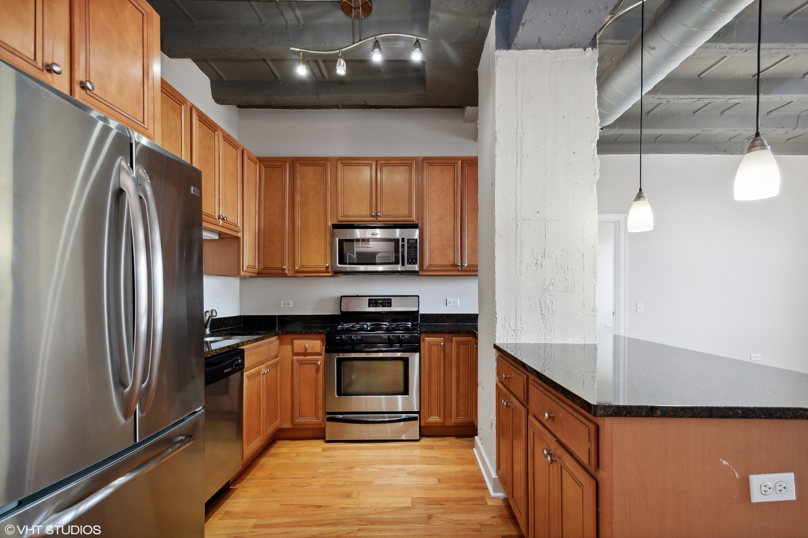 1791 West Howard Street, Unit 504 Chicago, IL 60626 - Photo 8 of 23 a kitchen with stainless steel appliances granite countertop a refrigerator a stove and a sink with wooden floor
