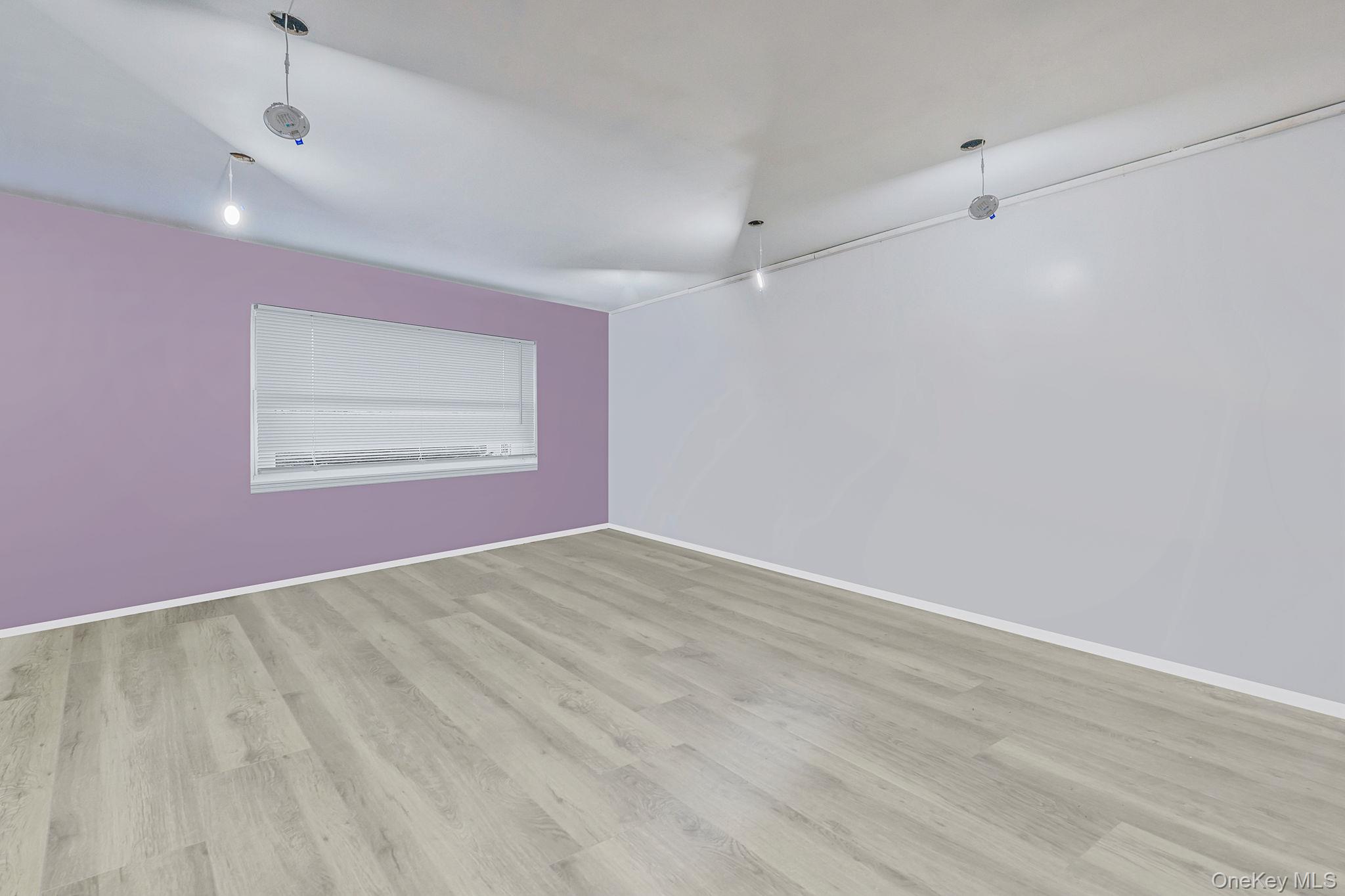 179-49 Eveleth Road Queens, NY 11434 - Photo 6 of 17 an empty room with wooden floor and windows