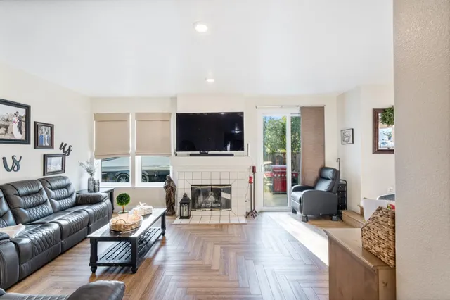 a living room with furniture a flat screen tv and a fireplace