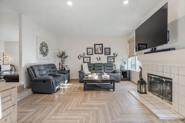 a living room with furniture a flat screen tv and a fireplace