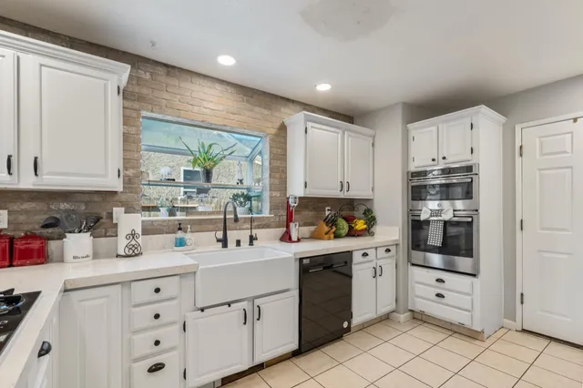a kitchen with white cabinets and white appliances