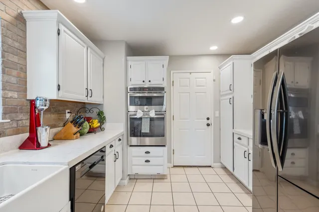 a kitchen with stainless steel appliances a refrigerator and a stove top oven