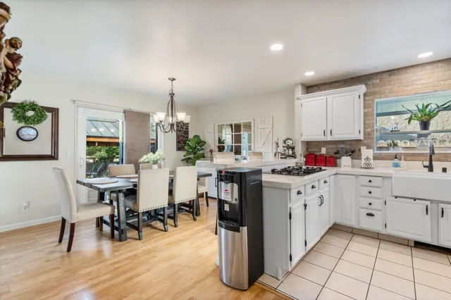 a kitchen with white cabinets and sink