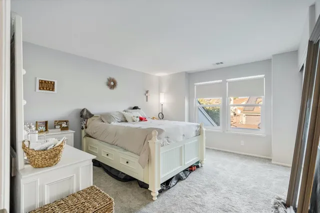 a white bed sitting in a room next to a window