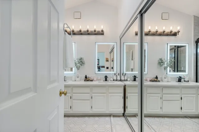 a bathroom with double vanity and a mirror