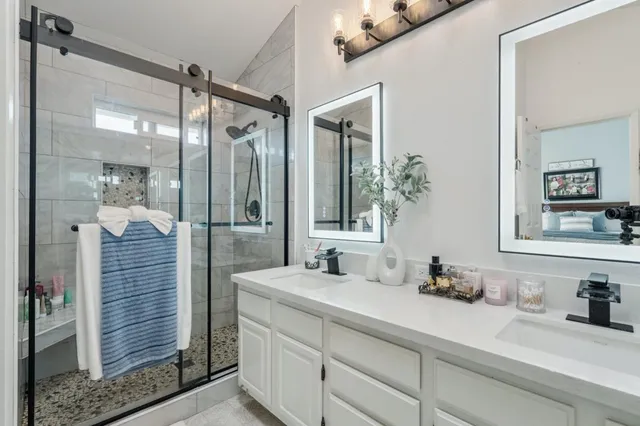a bathroom with a granite countertop sink mirror and shower