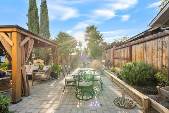 a view of a patio with couches table and chairs and potted plants
