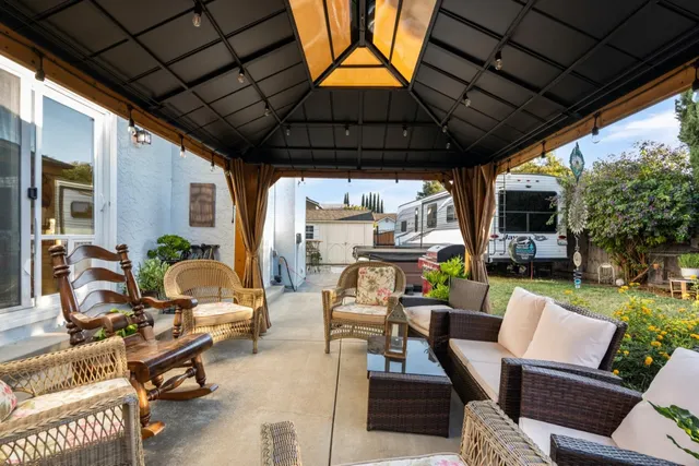 a living room with patio furniture and a potted plant
