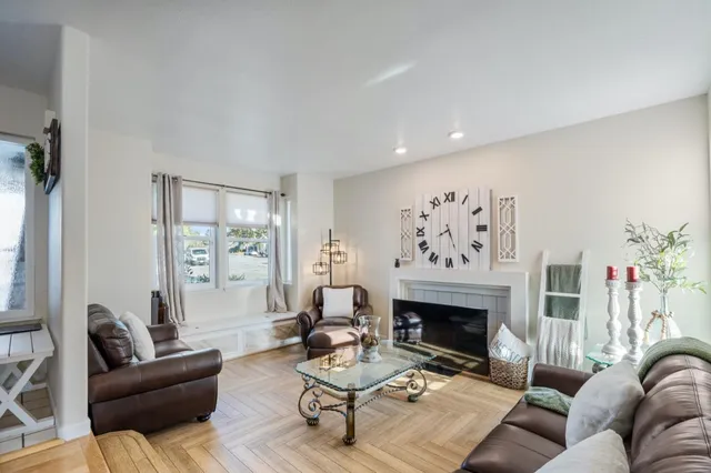 a living room with furniture a fireplace and a large window