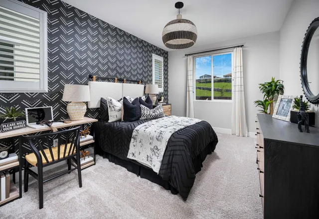 a spacious bedroom with a bed and a chandelier