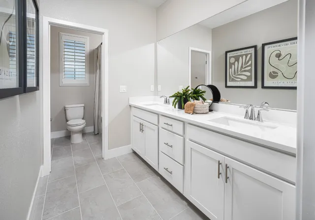 a spacious bathroom with a granite countertop toilet sink and mirror