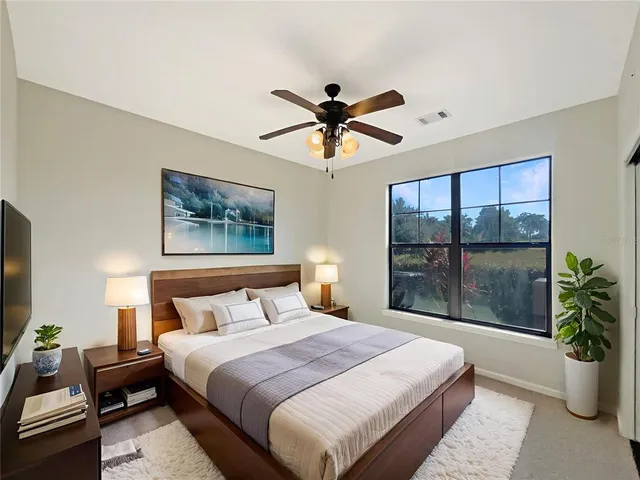 a bedroom with a large bed and a potted plant
