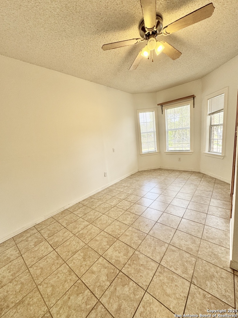 22739 Lazy Stream Drive Elmendorf, TX 78112 - Photo 12 of 20 a view of an empty room and window with a chandelier fan