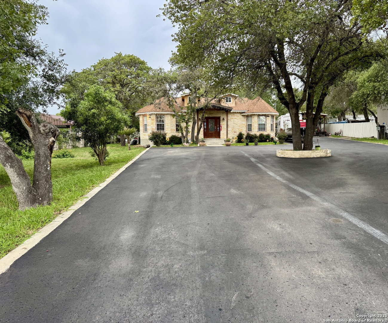 22739 Lazy Stream Drive Elmendorf, TX 78112 - Photo 17 of 20 a view of a white house with a large windows and a road