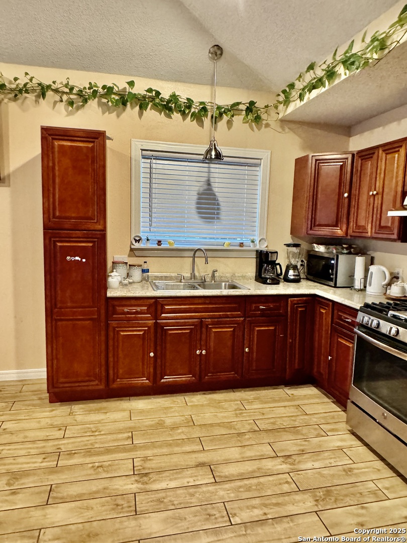 22739 Lazy Stream Drive Elmendorf, TX 78112 - Photo 4 of 20 a kitchen with stainless steel appliances granite countertop a stove a sink and a microwave