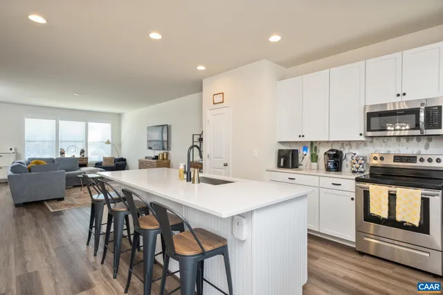a kitchen with a table chairs a sink dishwasher and cabinets with wooden floor