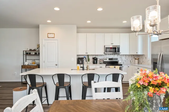 a kitchen with cabinets and chairs in it