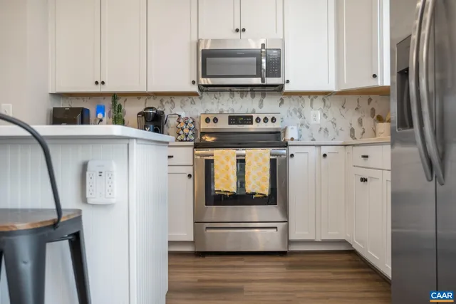 a kitchen with stainless steel appliances granite countertop a refrigerator and a stove