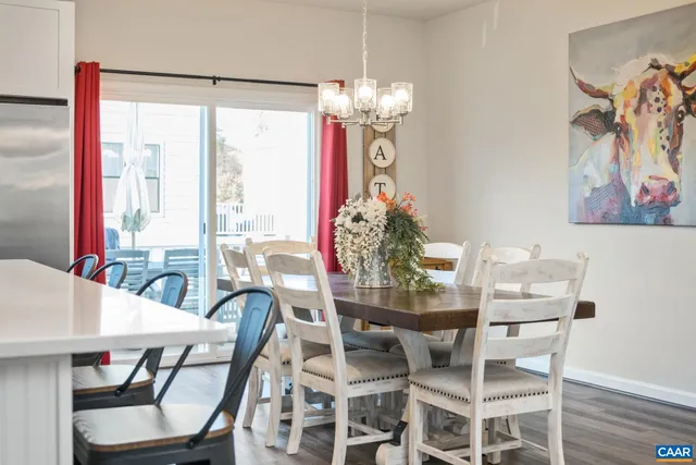 a dining room with furniture a large window and wooden floor