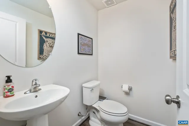 a bathroom with a sink mirror and toilet