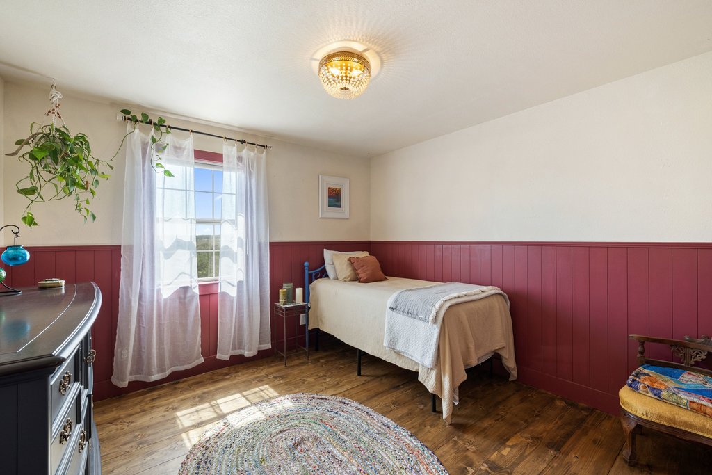 290 Sunset Ridge Dripping Springs, TX 78620 - Photo 16 of 39 Bedroom featuring wainscoting, hardwood / wood-style floors, and wood walls