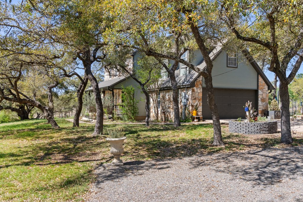 290 Sunset Ridge Dripping Springs, TX 78620 - Photo 31 of 39 View of front of house featuring stone siding, a front yard, and driveway