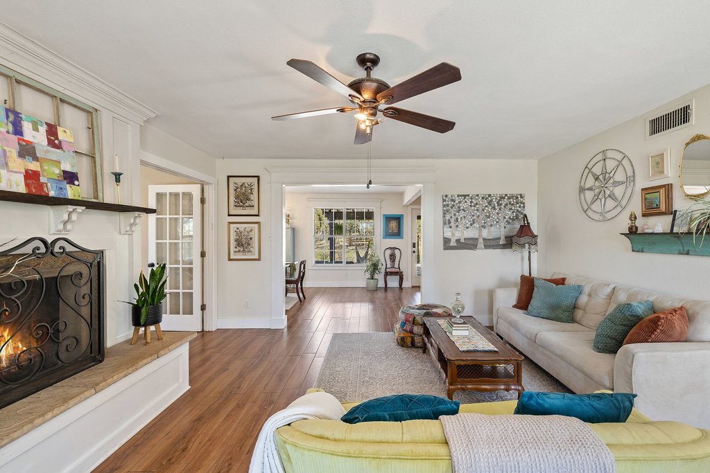 290 Sunset Ridge Dripping Springs, TX 78620 - Photo 5 of 39 Living area with wood finished floors, a lit fireplace, and a ceiling fan