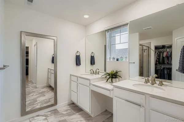 a bathroom with a double vanity sink mirror and shower