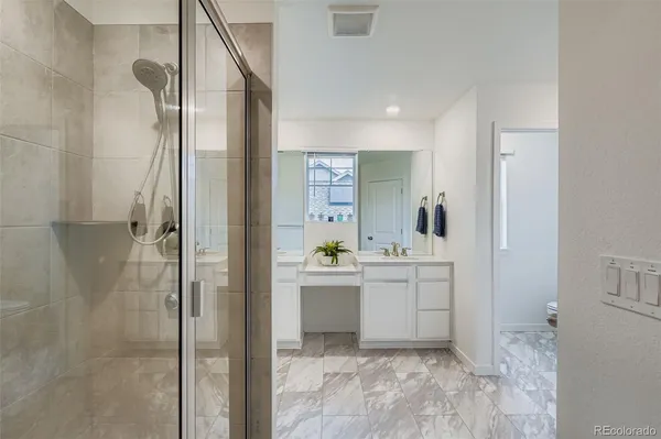 a bathroom with a sink and mirror with shower