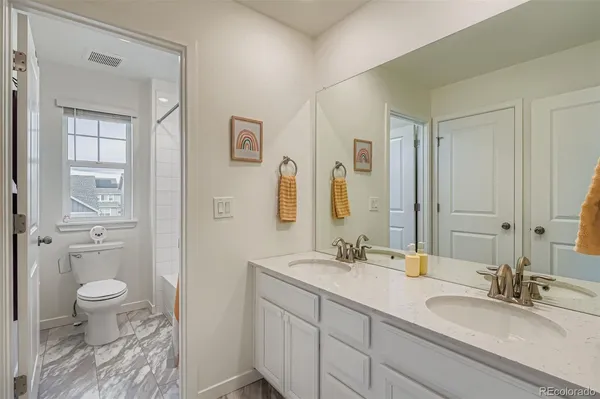 a bathroom with a granite countertop sink toilet a large mirror and shower